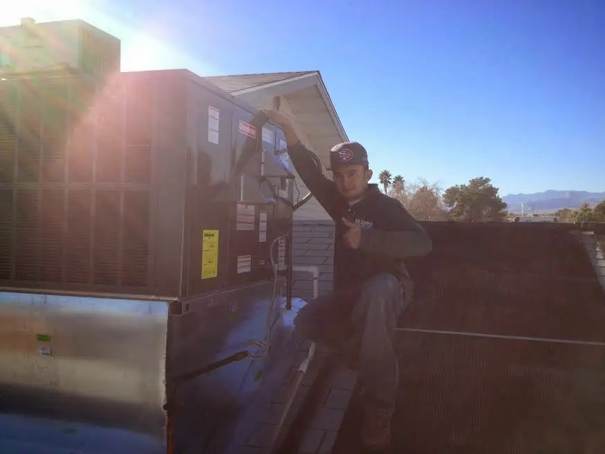 HVAC technician performing HVAC Inspection on a rooftop unit in Creve Coeur